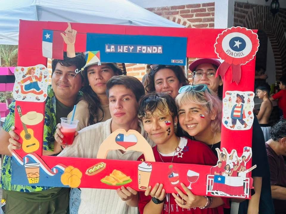 Un grupo de siete jóvenes apretados dentro del marco, uno con la bandera pintada en la cara y otro con un terremoto en la mano.